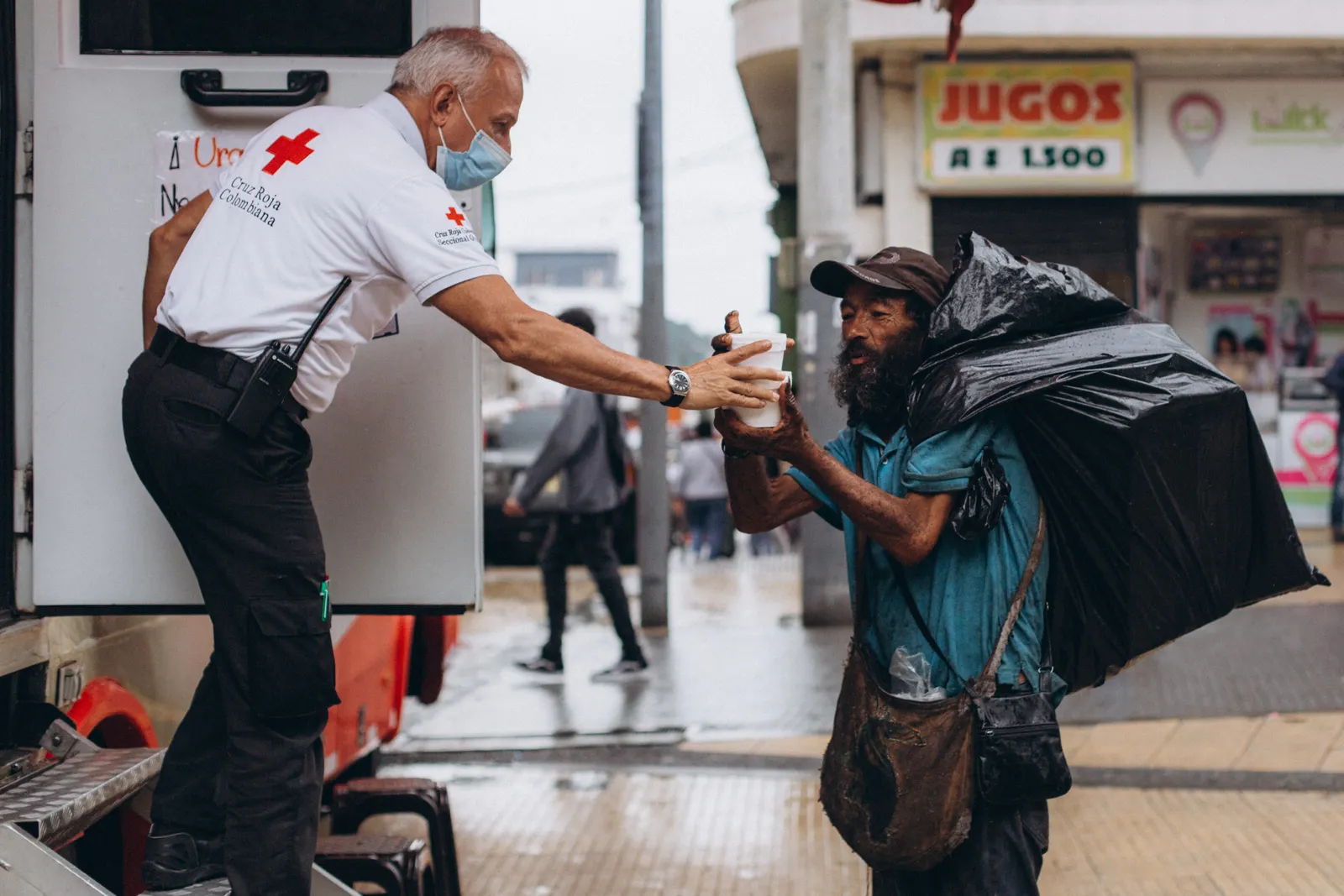 One person offering food to another person in need